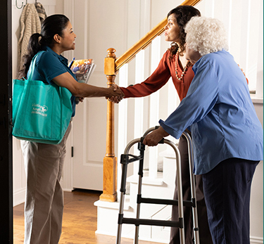 Adult child and senior mother meet a Visiting Angels for an in-home consultation.