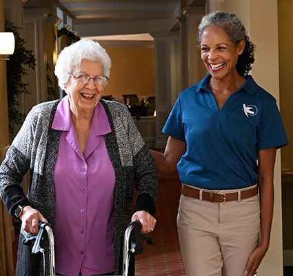 A Visiting Angels caregiver and an elderly woman sharing a joyful moment together, highlighting the importance of companionship in care services.